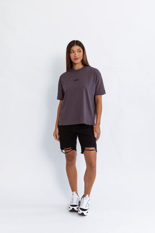 A model wearing a grey oversized kohz bb t-shirt with a puff printed logo, crew neck, and short sleeves standing against a white background.