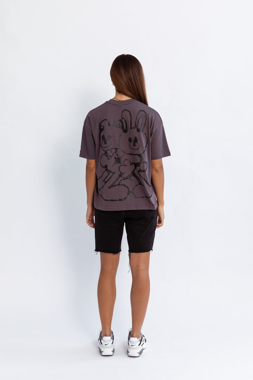 A model wearing a grey oversized kohz bb t-shirt with a puff printed logo, crew neck, and short sleeves standing against a white background.