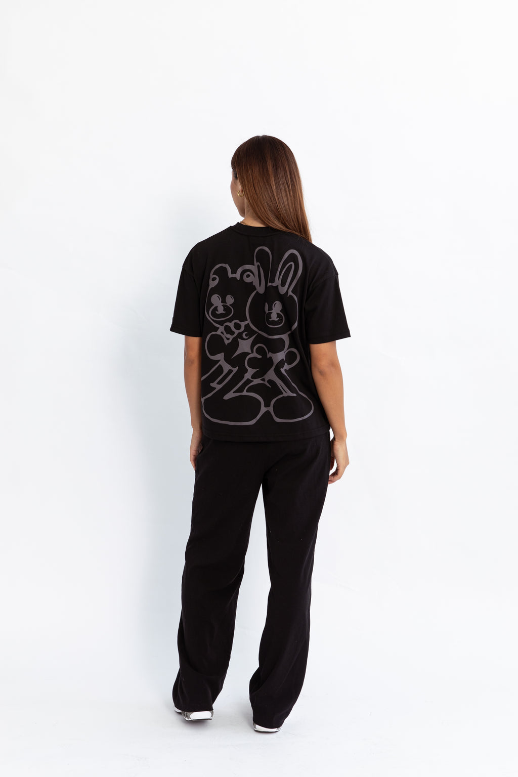 A model wearing a black oversized kohz bb t-shirt with a puff printed logo, crew neck, and short sleeves standing against a white background.
