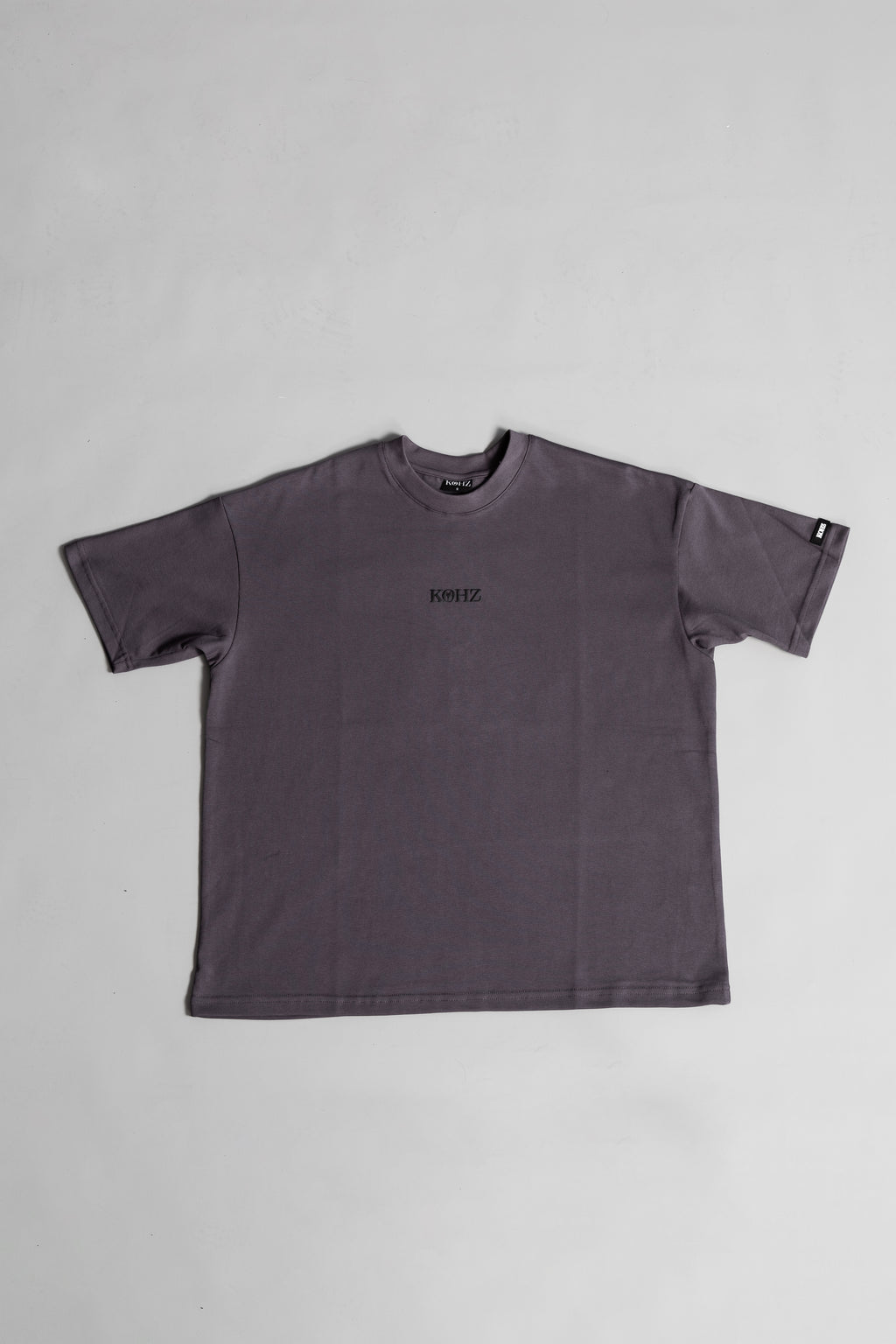 front of grey oversized crewneck t-shirt with ribbed sleeves and a puff printed logo on the chest.