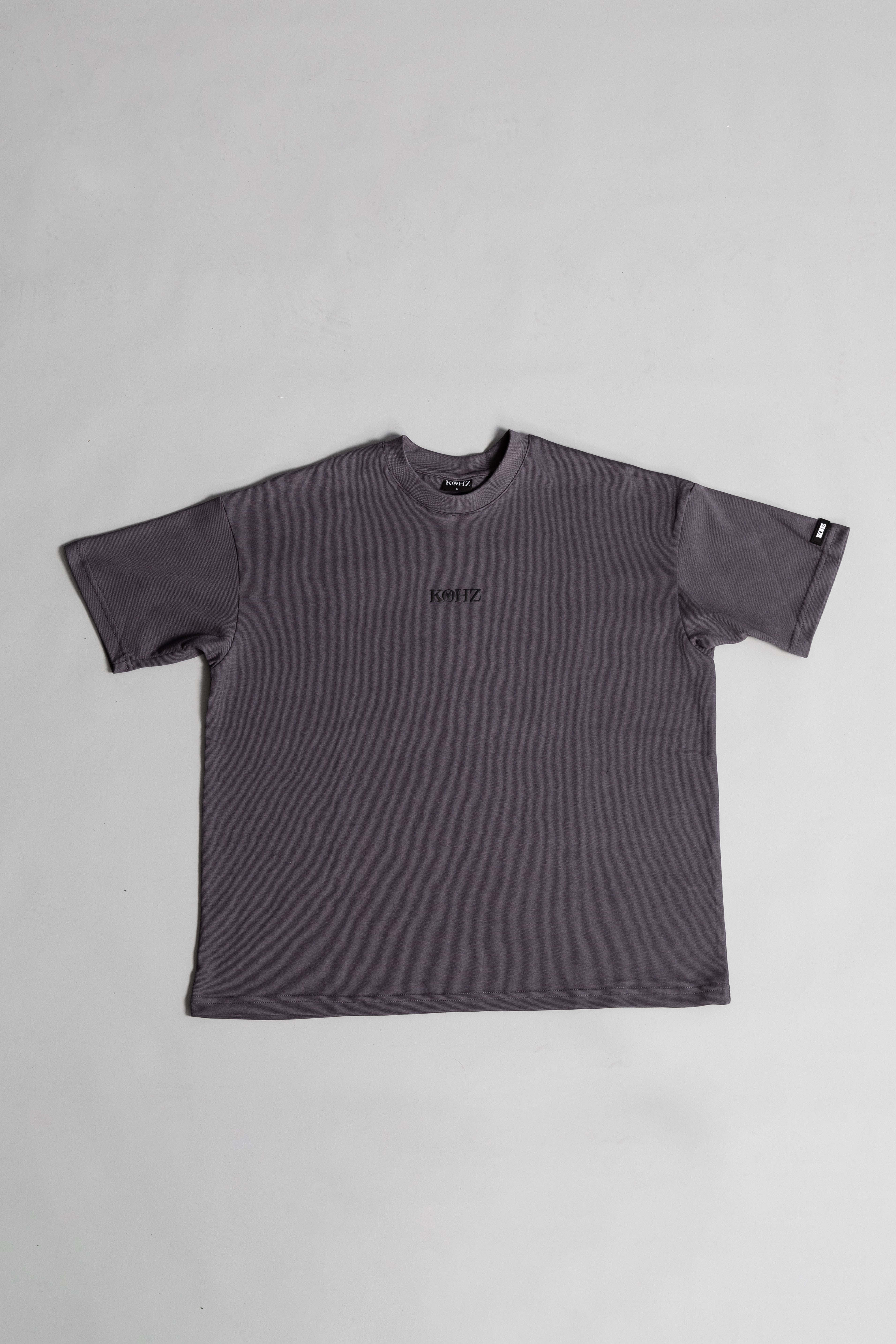 front of grey oversized crewneck t-shirt with ribbed sleeves and a puff printed logo on the chest.