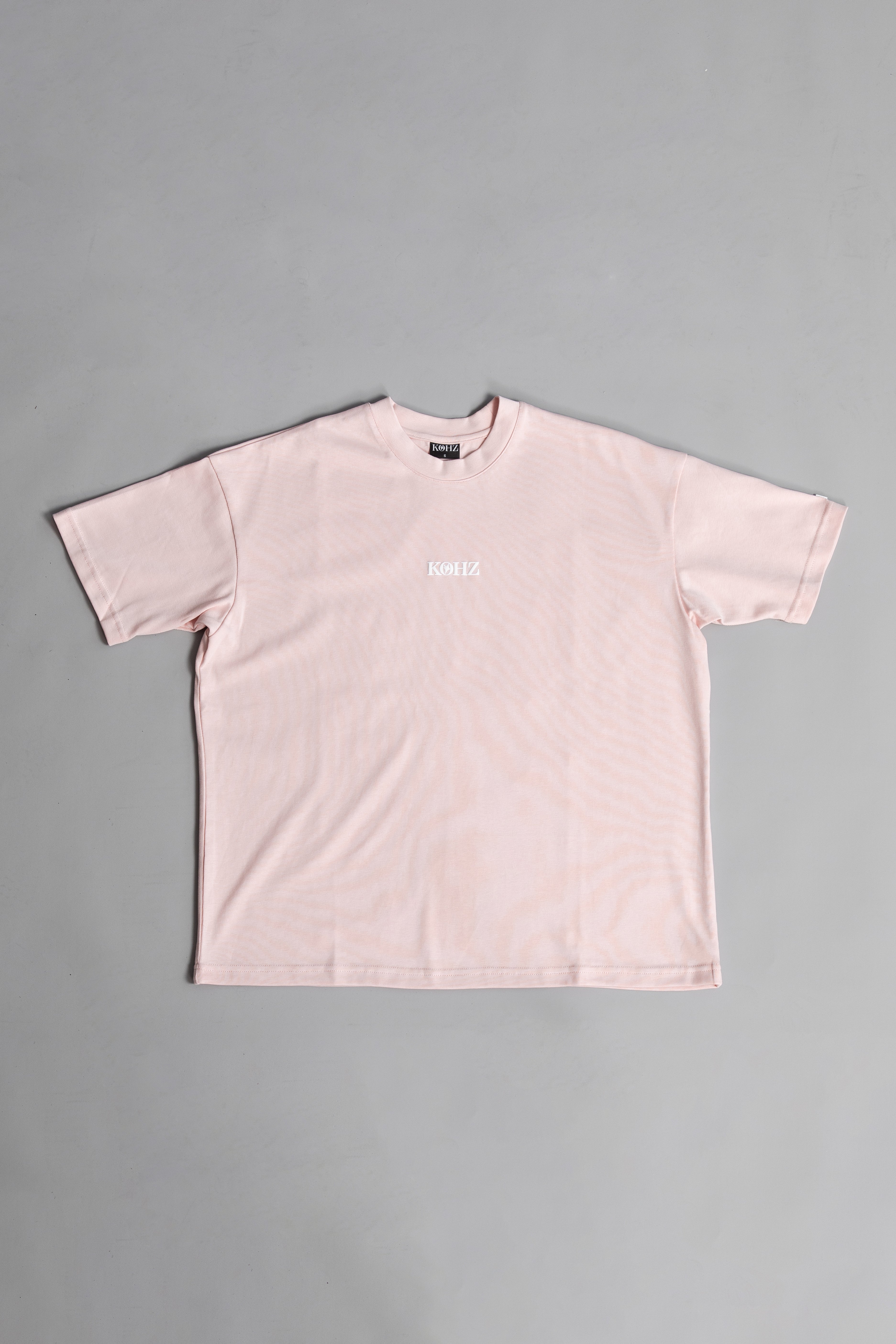 Front of Pink oversized crewneck t-shirt with ribbed sleeves and a puff printed logo on the chest.