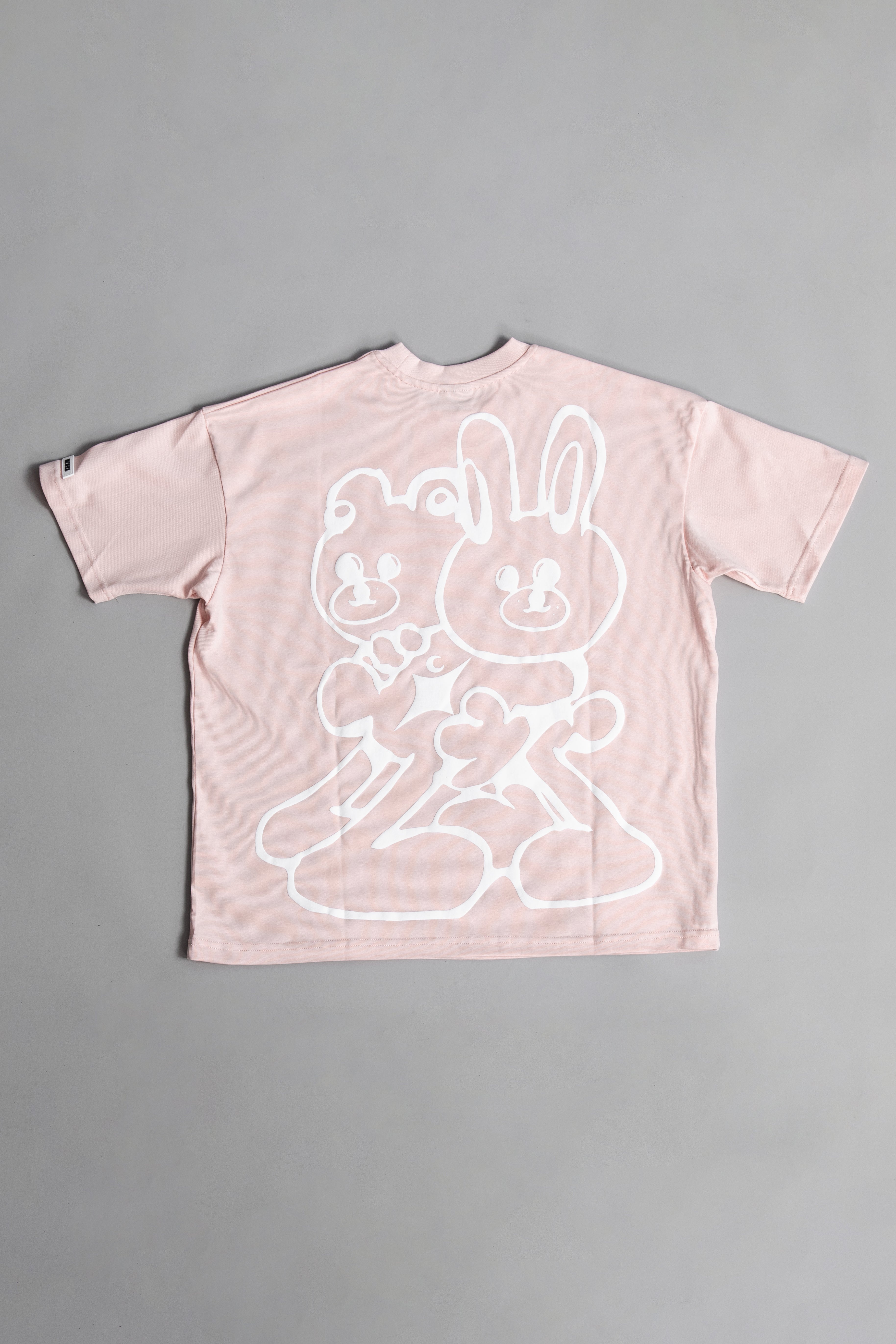 Back of Pink oversized crewneck t-shirt with ribbed sleeves and a puff printed logo on the chest.