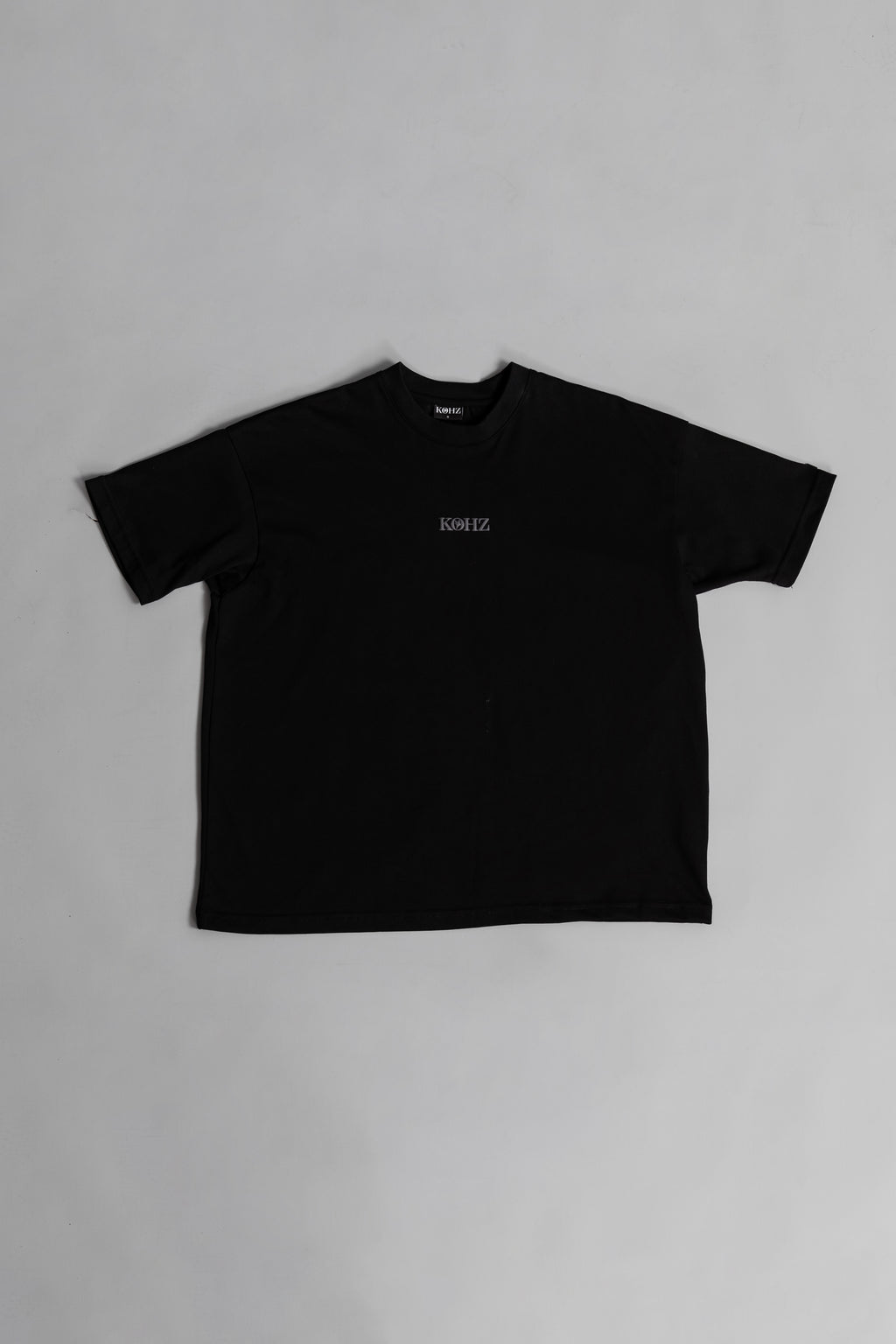 Black oversized crewneck t-shirt with ribbed sleeves and a puff printed logo on the chest.
