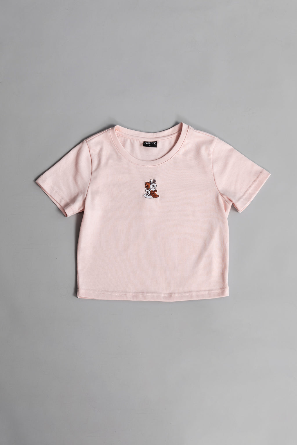 A pink crewneck kohz bb crop t-shirt with embroidery on the chest.