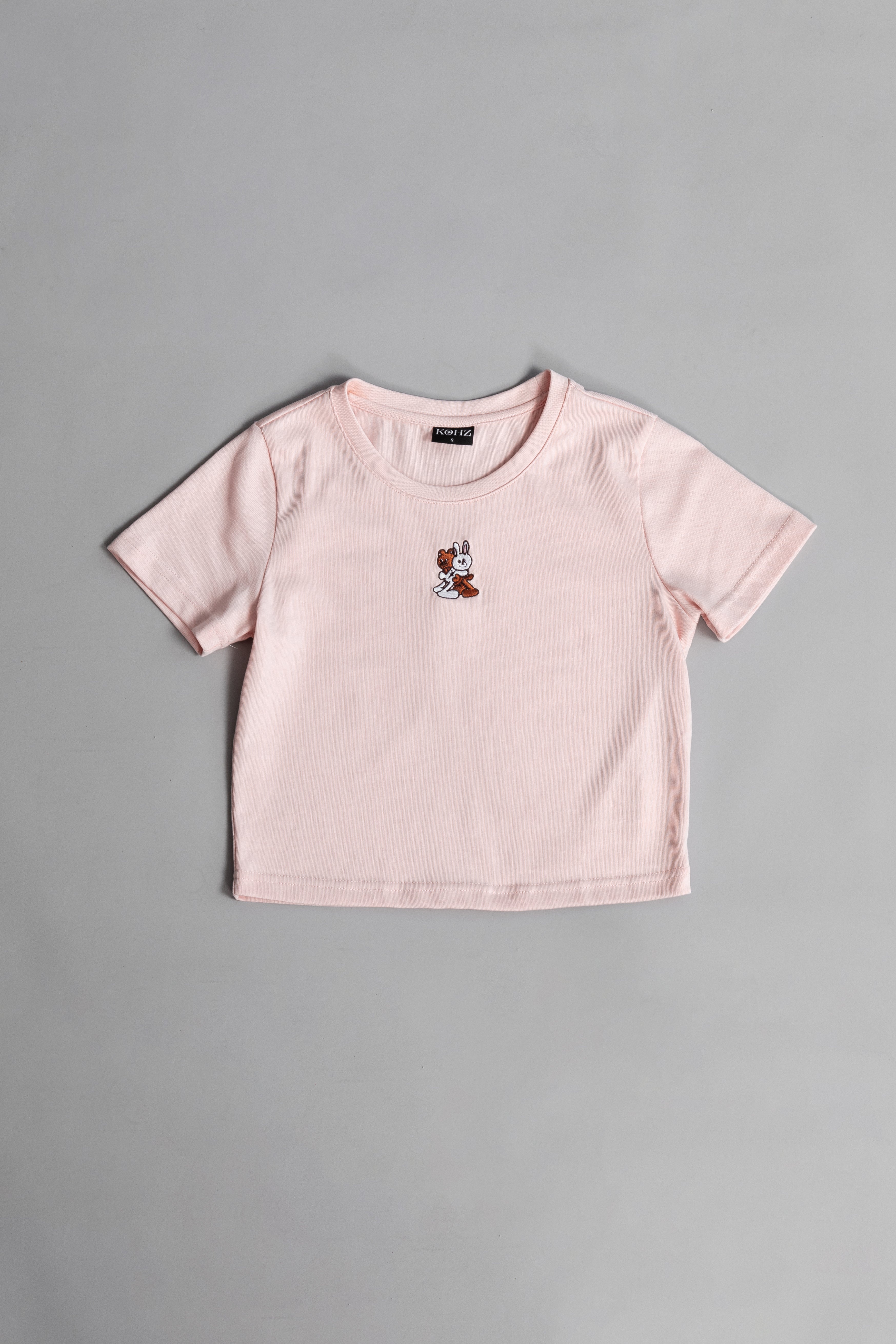 A pink crewneck kohz bb crop t-shirt with embroidery on the chest.
