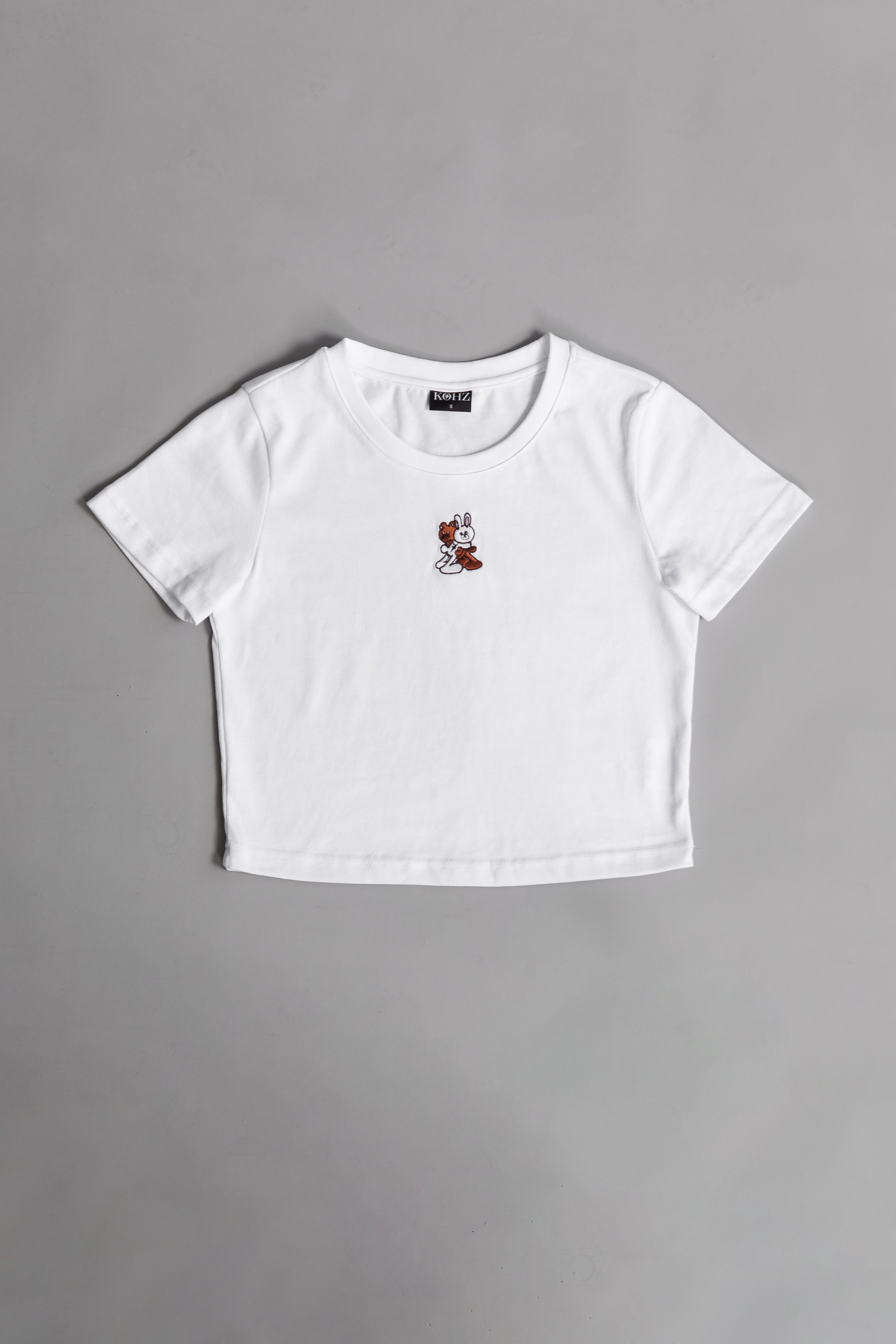 A white crewneck kohz bb crop t-shirt with embroidery on the chest.