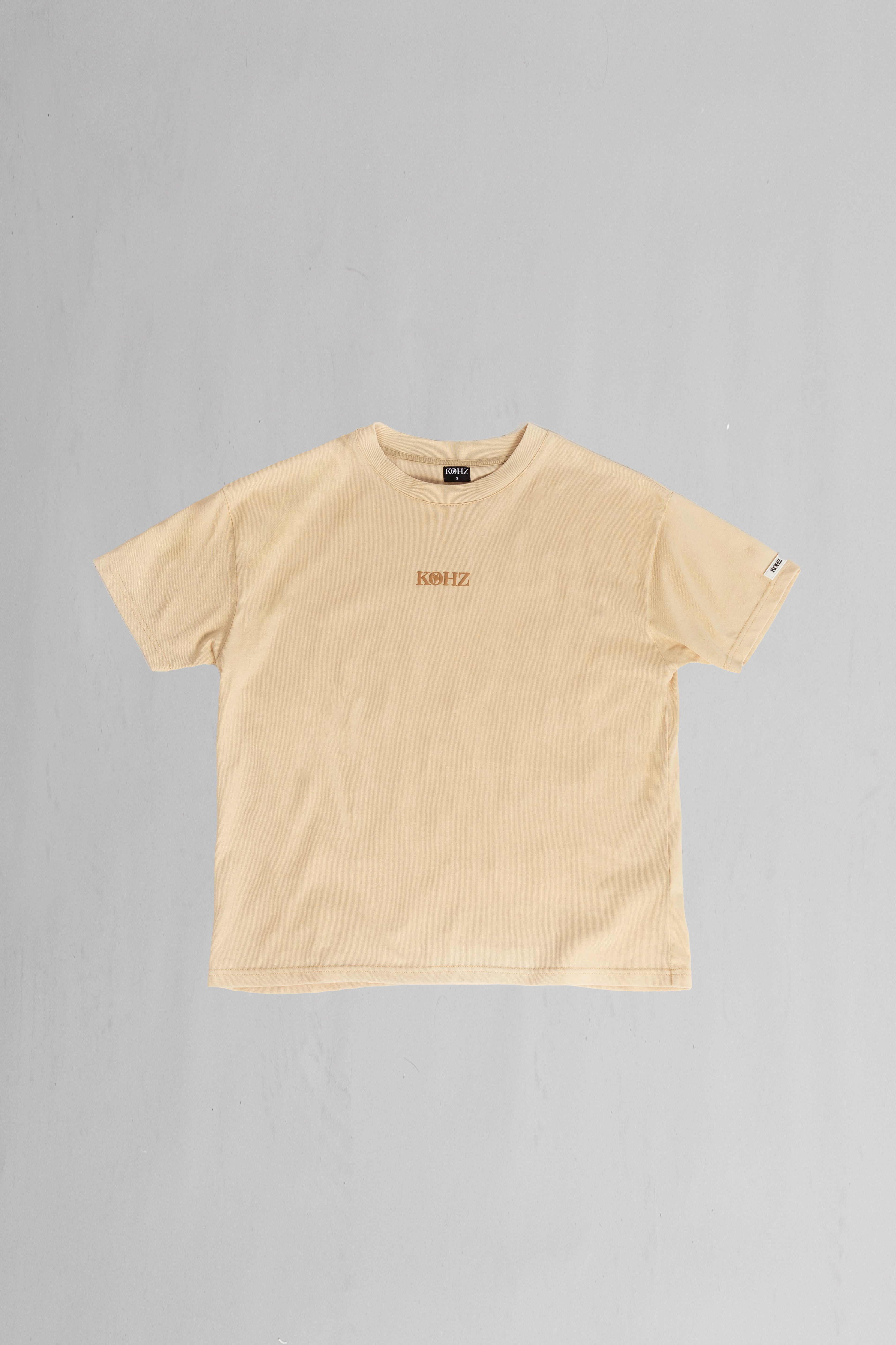 front of beige oversized crewneck t-shirt with ribbed sleeves and a puff printed logo on the chest.